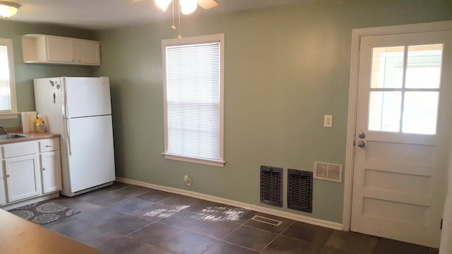 143 39th Ave N, Nashville, TN 37209 - kitchen with visible vents, ceiling fan, freestanding refrigerator, white cabinets, and a sink