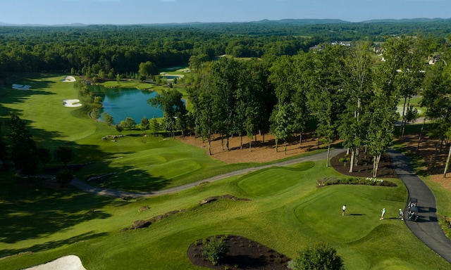 birds eye view of property with a view of trees, a water view, and golf course view