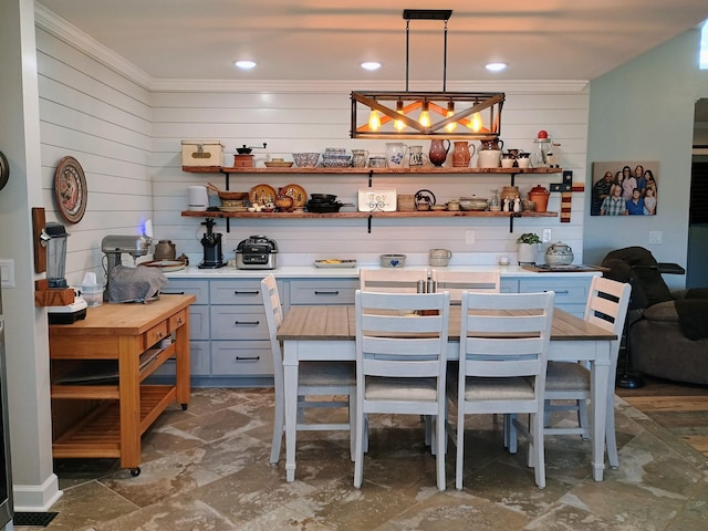 interior space featuring stone finish floor, crown molding, and wood walls