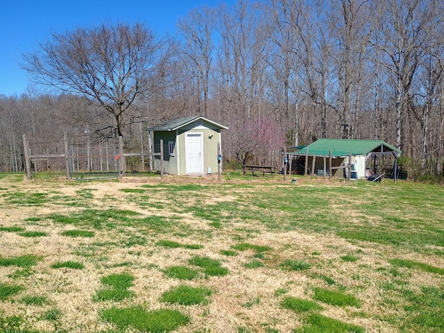 view of yard with a view of trees, an outbuilding, and a shed