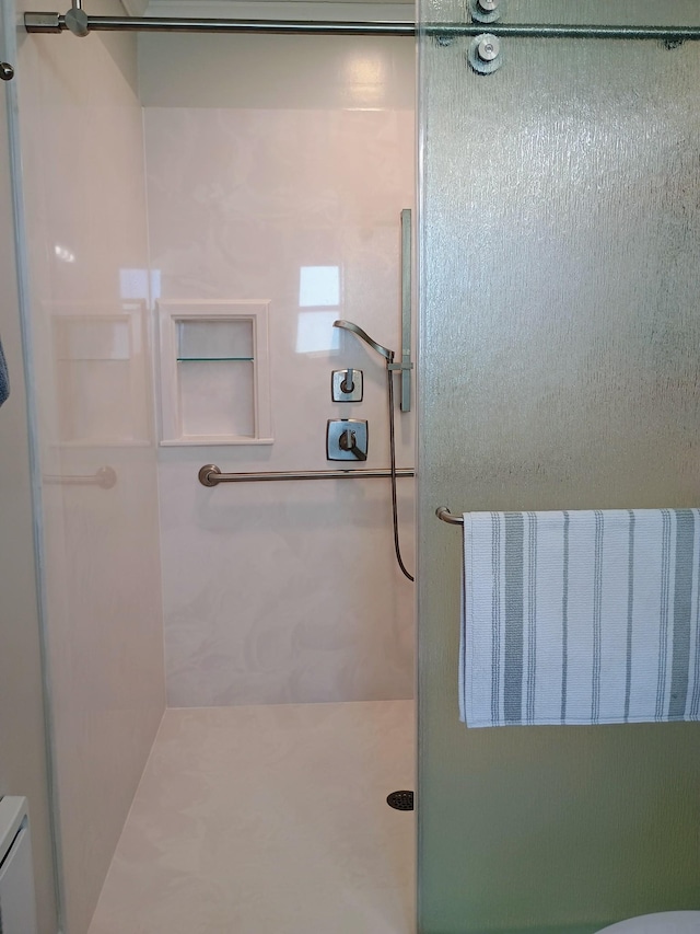 bathroom with a shower stall and toilet