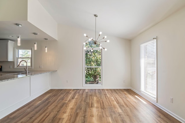 1106 Roseland Dr, Columbia, TN 38401 - kitchen with a chandelier, hanging light fixtures, a sink, light stone countertops, and wood finished floors