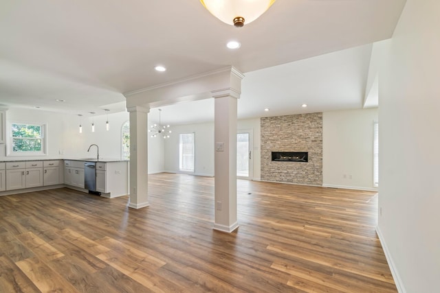 1106 Roseland Dr, Columbia, TN 38401 - unfurnished living room with dark wood finished floors, a sink, decorative columns, and a stone fireplace