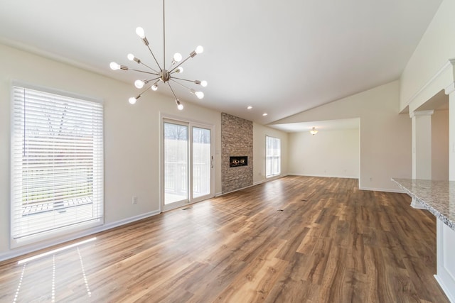 1106 Roseland Dr, Columbia, TN 38401 - unfurnished living room featuring a notable chandelier, wood finished floors, a fireplace, and vaulted ceiling