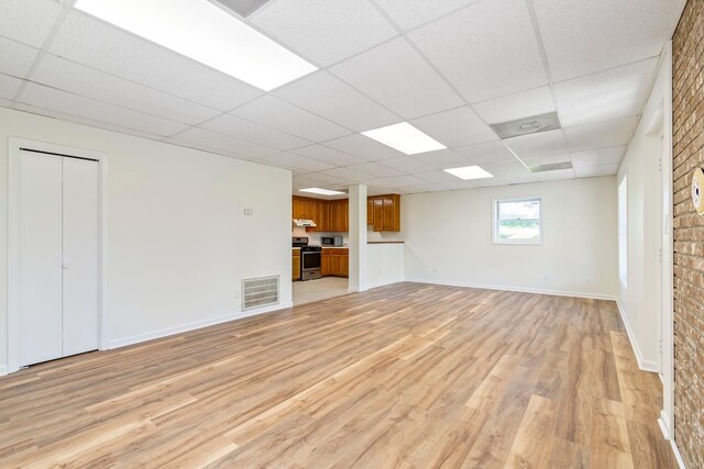 1106 Roseland Dr, Columbia, TN 38401 - unfurnished living room featuring baseboards, visible vents, a paneled ceiling, and light wood-type flooring