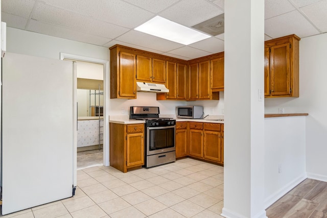 1106 Roseland Dr, Columbia, TN 38401 - kitchen featuring light countertops, stainless steel appliances, under cabinet range hood, brown cabinets, and a paneled ceiling