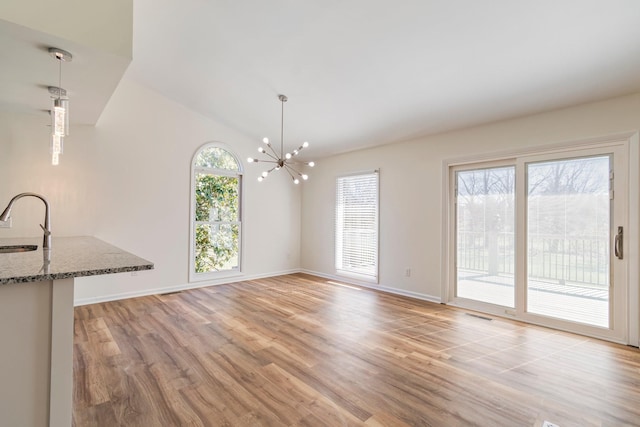 1106 Roseland Dr, Columbia, TN 38401 - unfurnished dining area with visible vents, baseboards, a sink, light wood-style floors, and an inviting chandelier