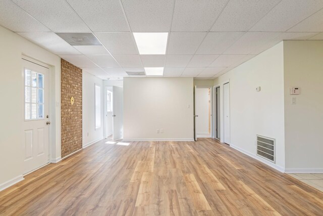 1106 Roseland Dr, Columbia, TN 38401 - empty room featuring baseboards, a drop ceiling, brick wall, light wood finished floors, and visible vents