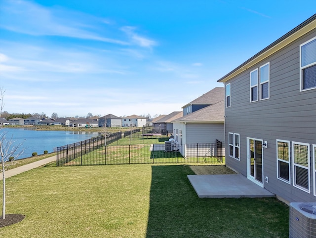 view of yard with a water view, fence, a patio, central AC, and a residential view
