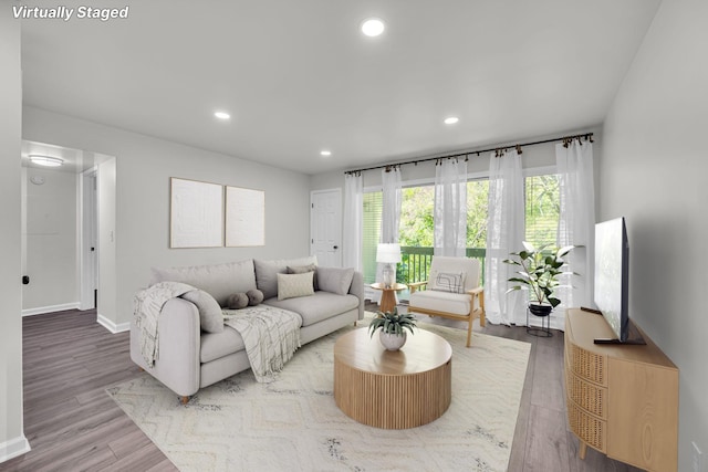 living room with recessed lighting, baseboards, and wood finished floors