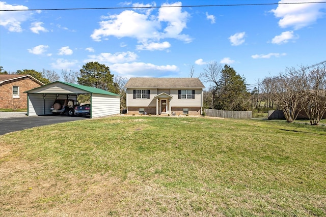 raised ranch featuring aphalt driveway, fence, a front yard, and a carport