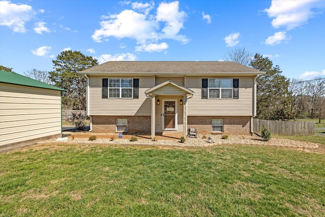 raised ranch with fence and a front lawn