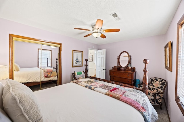 bedroom with carpet, a textured ceiling, visible vents, a ceiling fan, and a closet