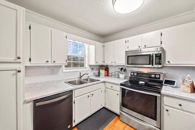 kitchen with a sink, white cabinets, and appliances with stainless steel finishes