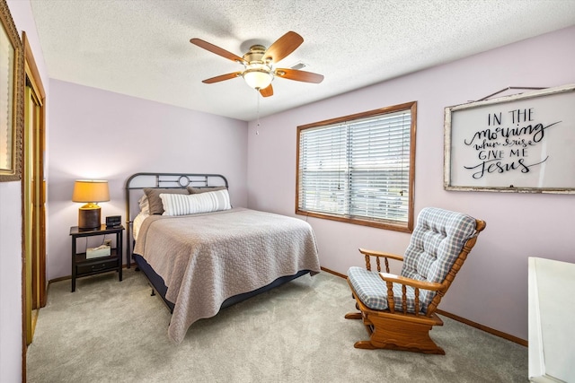 carpeted bedroom featuring baseboards, visible vents, ceiling fan, and a textured ceiling