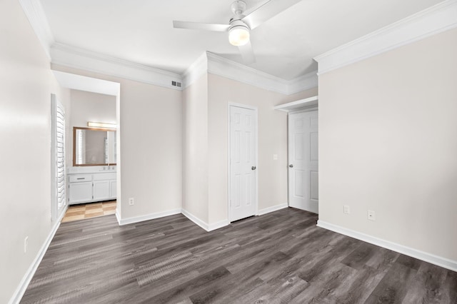 unfurnished bedroom with visible vents, crown molding, dark wood-type flooring, and baseboards