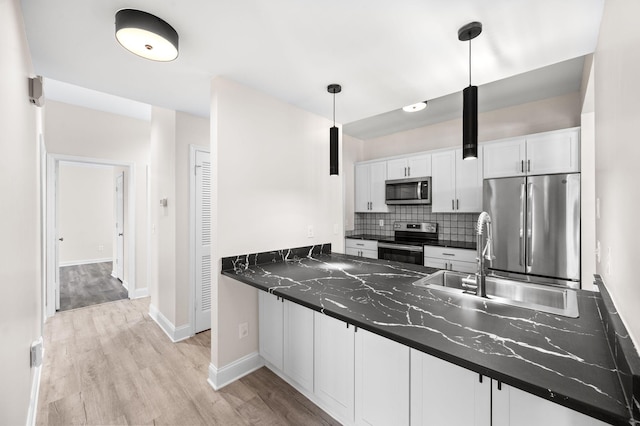 kitchen with a sink, dark countertops, tasteful backsplash, and stainless steel appliances