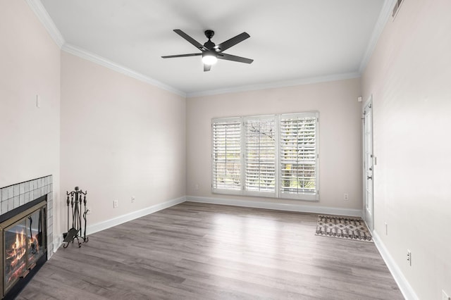 unfurnished living room featuring ceiling fan, wood finished floors, baseboards, and ornamental molding