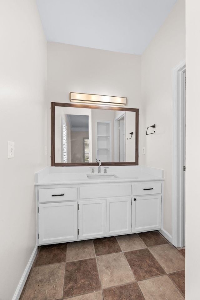 bathroom with baseboards, vanity, and stone finish floor