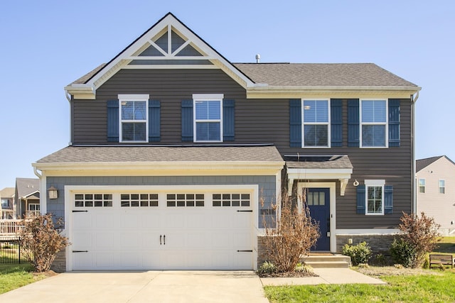 craftsman inspired home with concrete driveway, an attached garage, fence, and a shingled roof