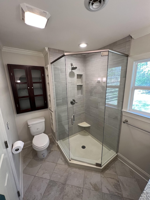 full bathroom featuring toilet, a stall shower, baseboards, and ornamental molding