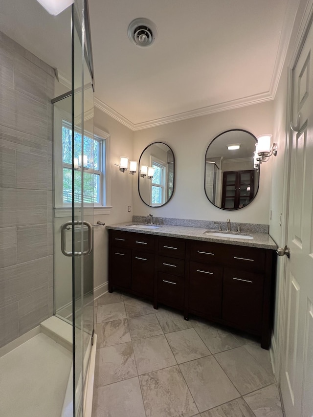 bathroom featuring a stall shower, a sink, and crown molding