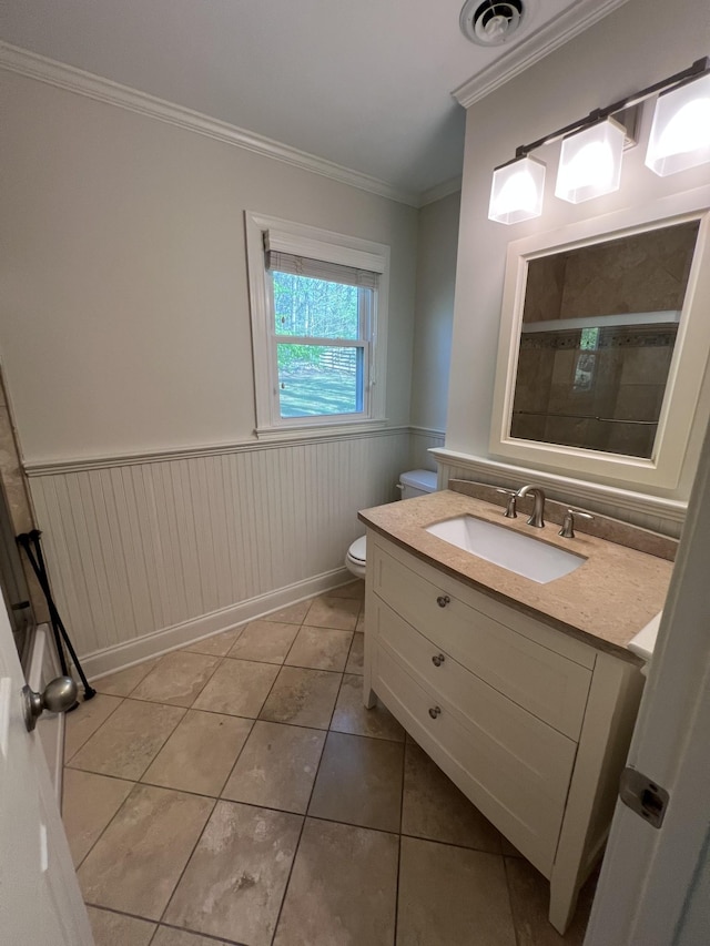 bathroom featuring crown molding, visible vents, a wainscoted wall, toilet, and tile patterned floors