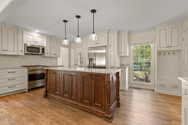 kitchen with a center island, wood finished floors, light stone counters, appliances with stainless steel finishes, and hanging light fixtures