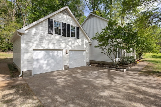 view of home's exterior featuring an attached garage and driveway