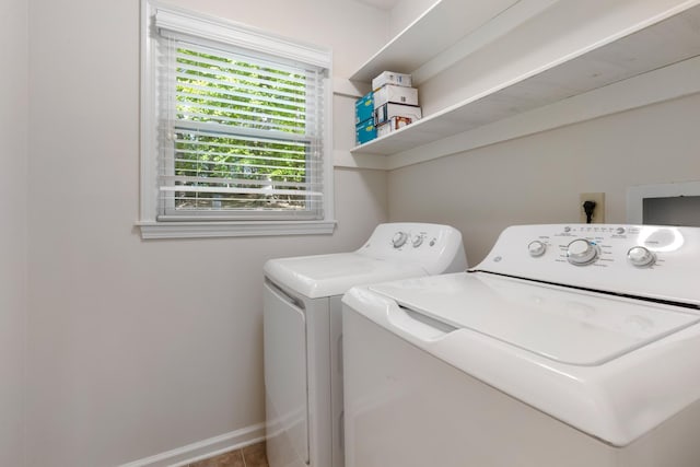 washroom with washing machine and dryer, baseboards, and laundry area