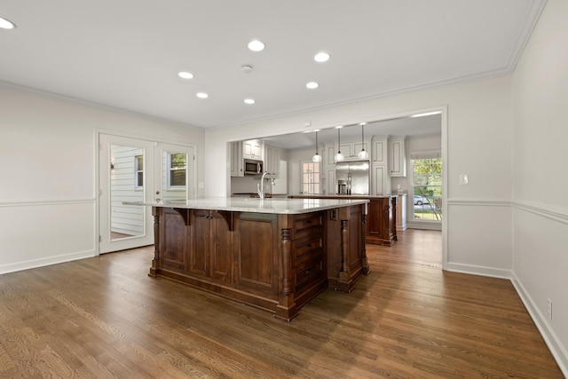 kitchen with crown molding, a large island, appliances with stainless steel finishes, dark wood-style flooring, and recessed lighting