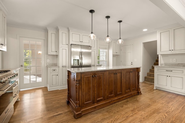 kitchen featuring white cabinets, appliances with stainless steel finishes, wood finished floors, and plenty of natural light