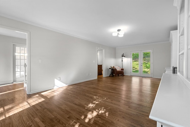 unfurnished living room with baseboards, crown molding, and wood finished floors