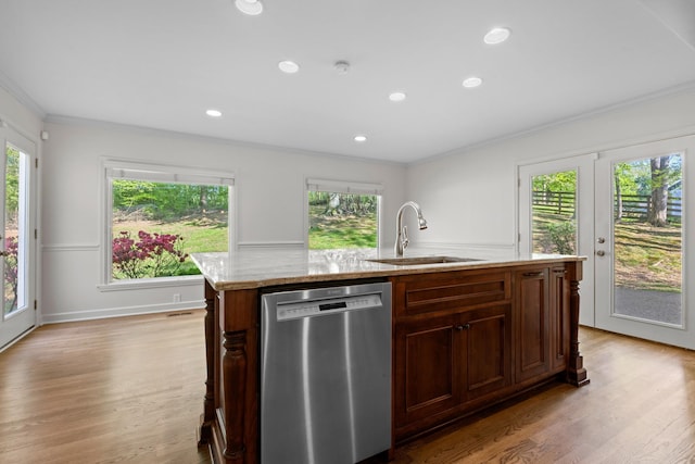 kitchen with light wood finished floors, stainless steel dishwasher, a sink, and crown molding