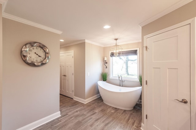 full bath featuring recessed lighting, a chandelier, a freestanding tub, baseboards, and wood finished floors