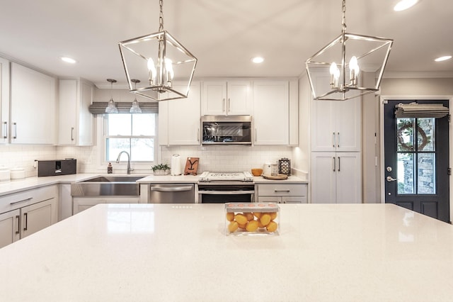 kitchen with recessed lighting, an inviting chandelier, appliances with stainless steel finishes, and a sink