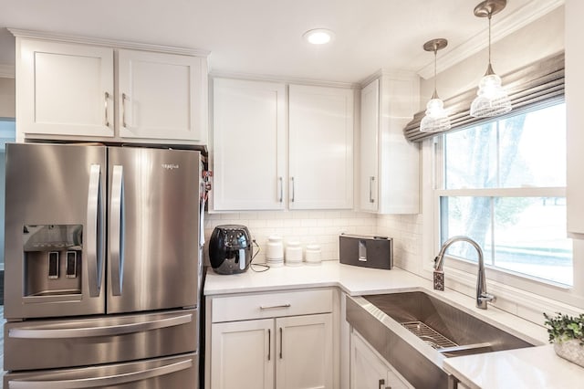 kitchen featuring white cabinets, a sink, stainless steel refrigerator with ice dispenser, and tasteful backsplash