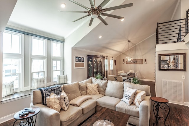 living area with ceiling fan, dark wood-type flooring, visible vents, ornamental molding, and plenty of natural light