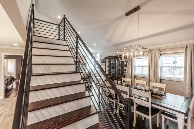 stairway featuring crown molding, an inviting chandelier, and wood finished floors
