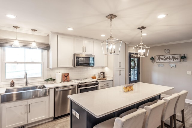 kitchen featuring decorative backsplash, a sink, a breakfast bar, stainless steel appliances, and light wood finished floors