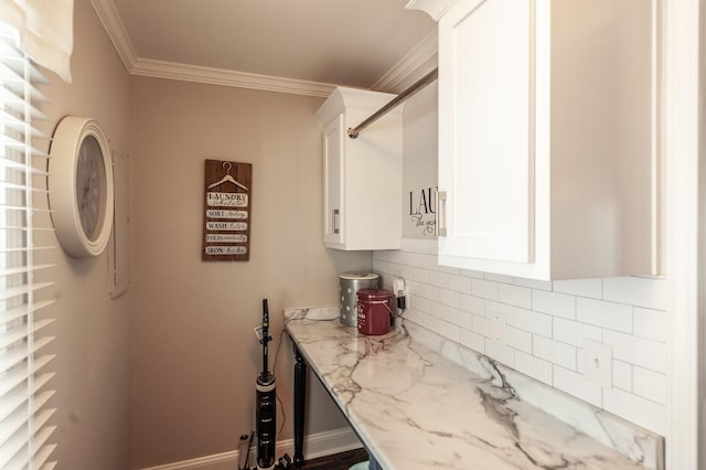 kitchen with light stone counters, decorative backsplash, white cabinetry, and crown molding
