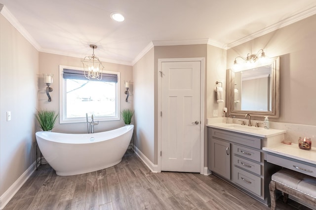 full bath with a soaking tub, baseboards, wood finished floors, vanity, and a notable chandelier