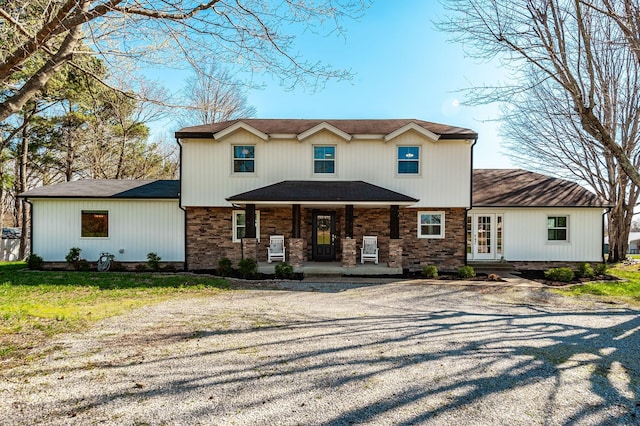 traditional-style home featuring covered porch and stone siding