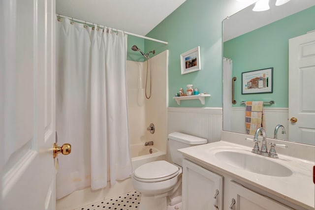 full bathroom with toilet, shower / bath combo with shower curtain, vanity, and wainscoting