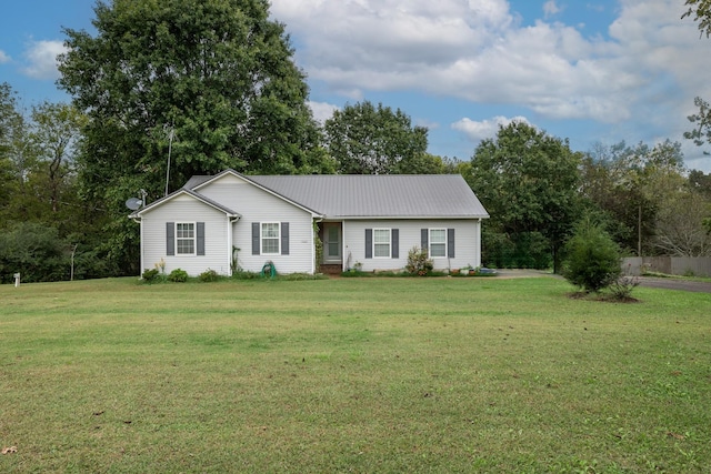ranch-style home featuring metal roof and a front lawn