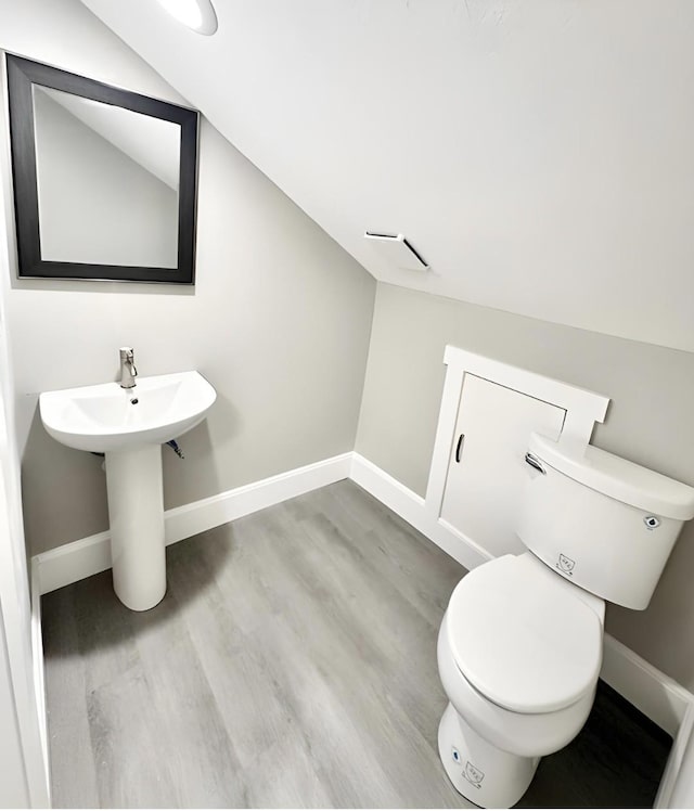 832 Richardson St, Clarksville, TN 37040 - bathroom featuring wood finished floors, lofted ceiling, baseboards, toilet, and a sink