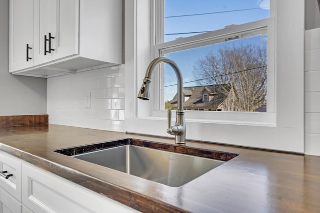832 Richardson St, Clarksville, TN 37040 - kitchen view of a sink, dark countertops, white cabinetry, and decorative backsplash