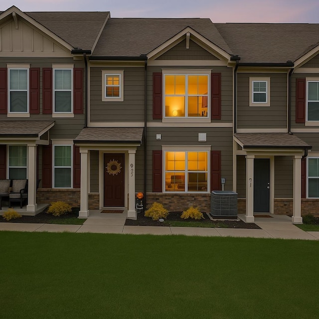 923 Long Train Aly, Antioch, TN 37013 - townhome / multi-family property with a shingled roof, a lawn, cooling unit, and stone siding