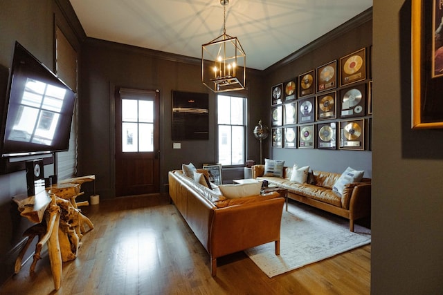 living area with a notable chandelier, wood finished floors, and crown molding