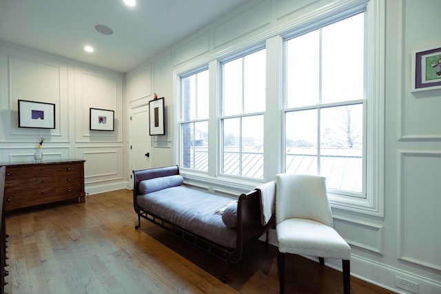 living area featuring recessed lighting, wood finished floors, and a decorative wall